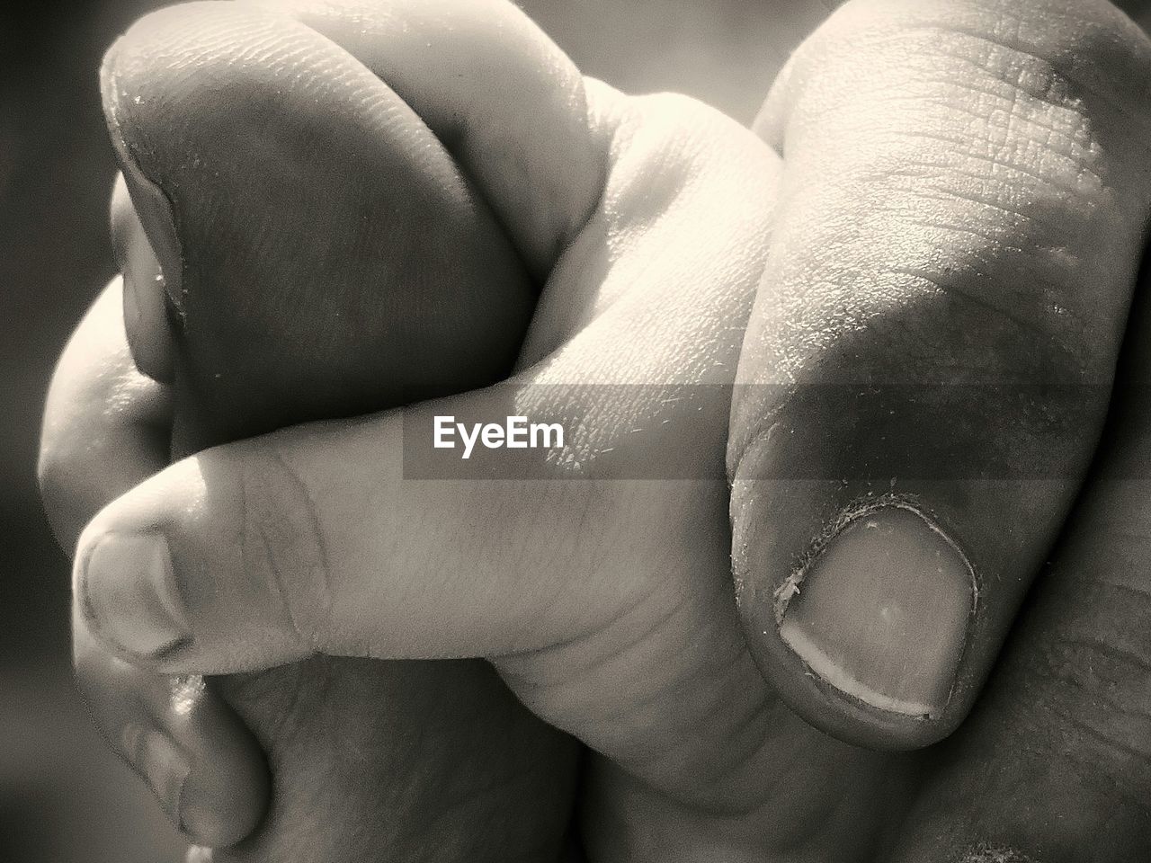 Close-up of cropped man holding baby hand