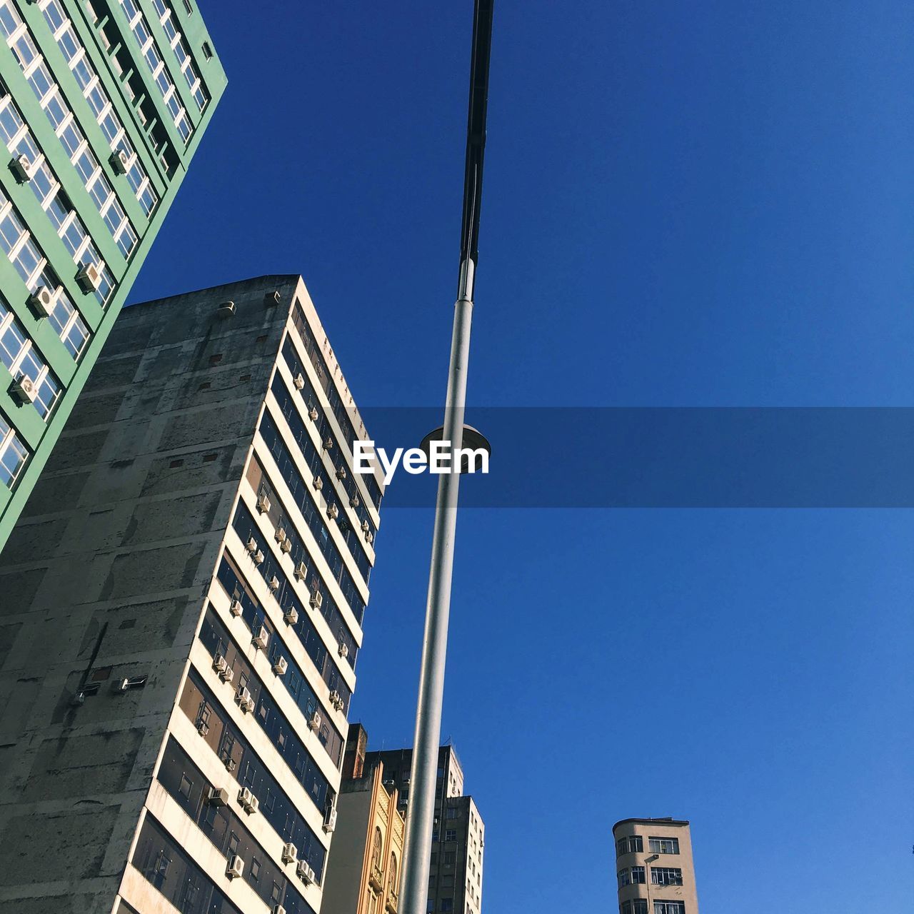 Low angle view of modern buildings against clear blue sky