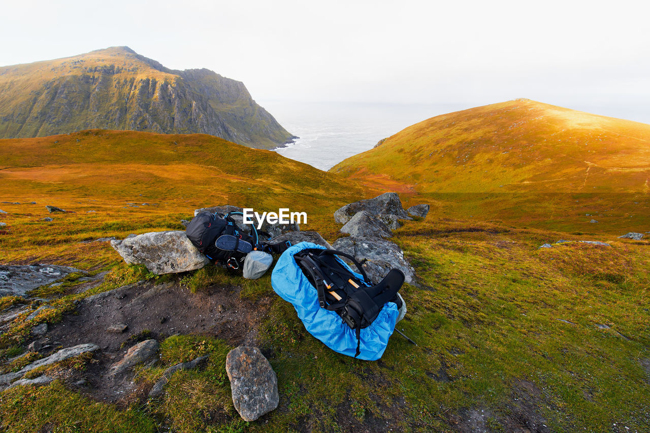 Two hiking backpacks on mountain with scenic view of coast and sea in moskenesoya lofoten norway