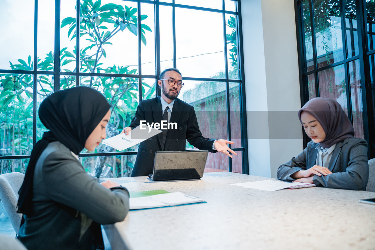 side view of business colleagues working at table