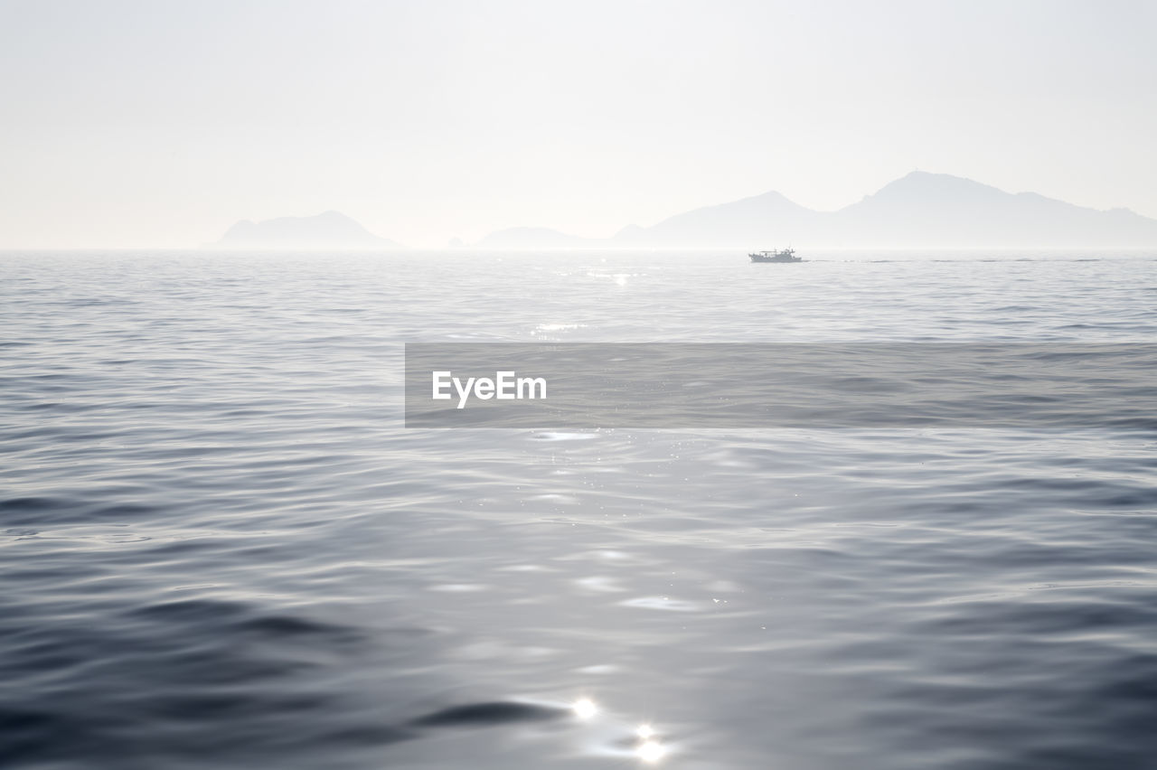 Scenic view of sea and mountains against sky