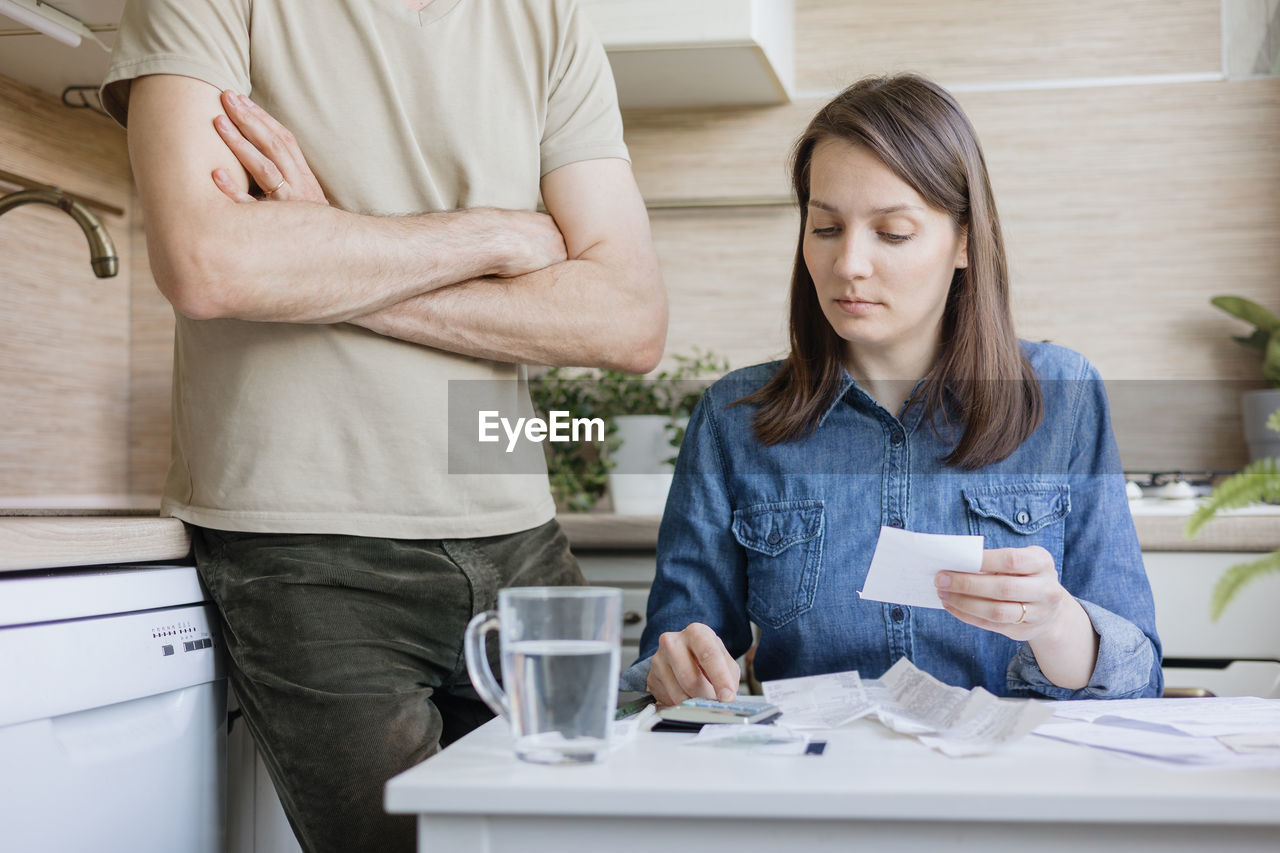 young woman using mobile phone while sitting at table