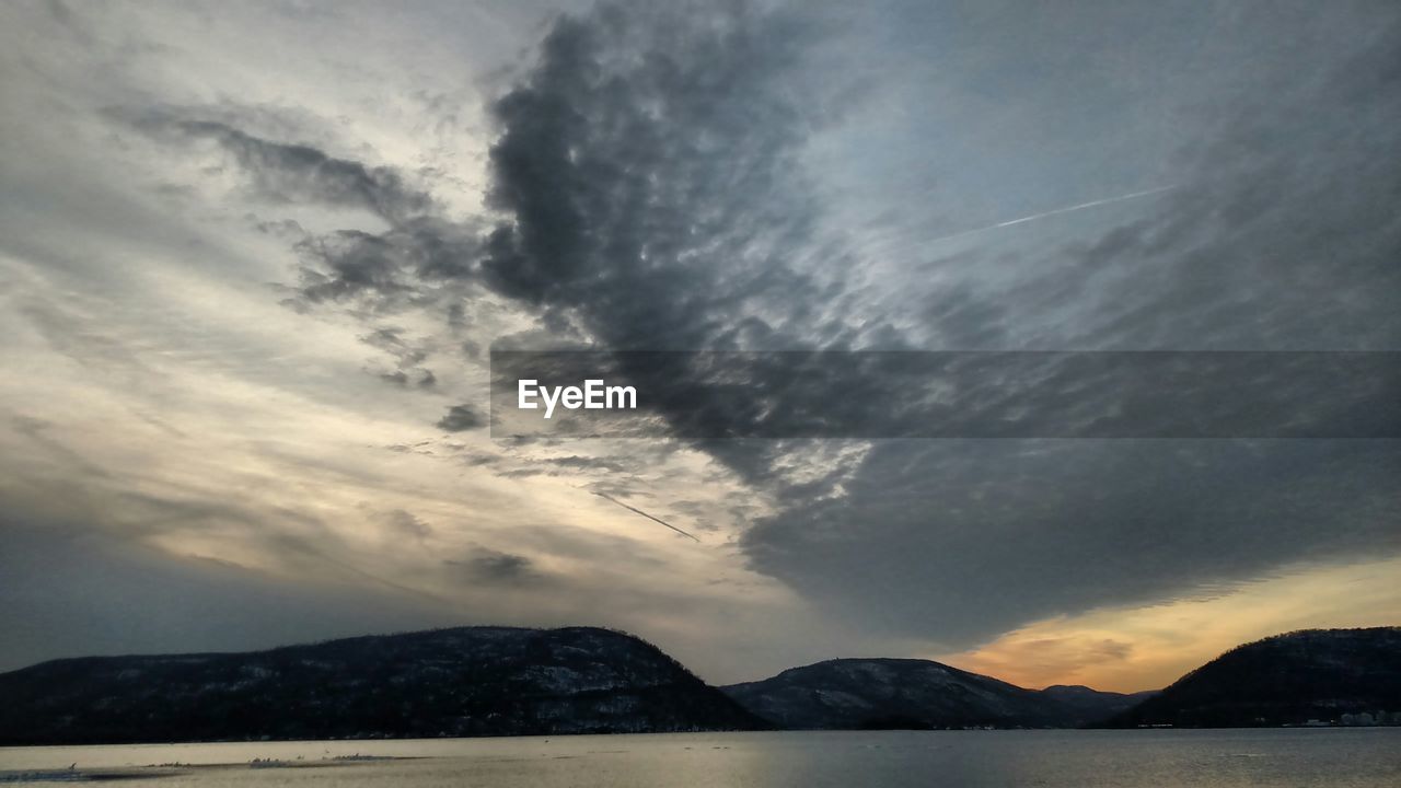 SCENIC VIEW OF MOUNTAINS AGAINST CLOUDY SKY