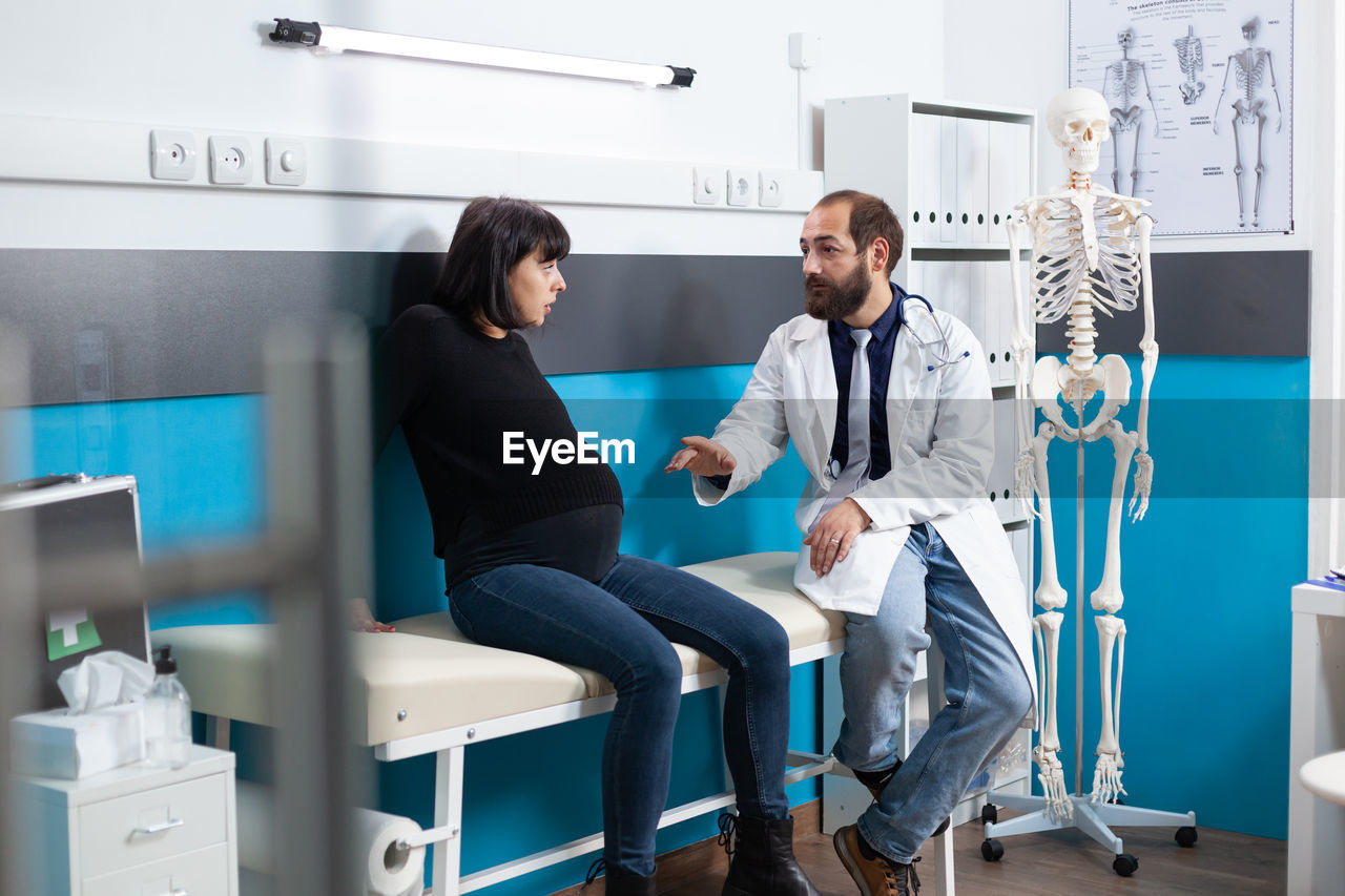 Midsection of doctor examining patient in hospital