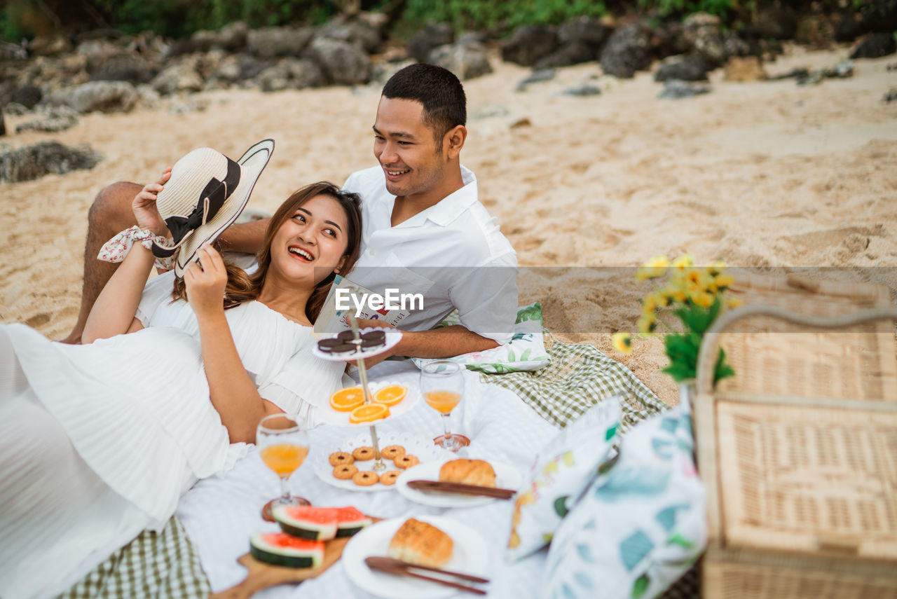 side view of couple sitting on table