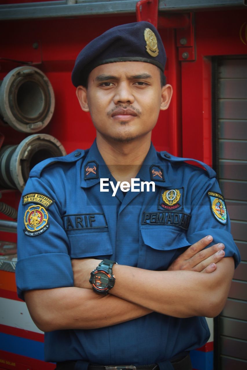 Portrait of smiling man standing in fire truck