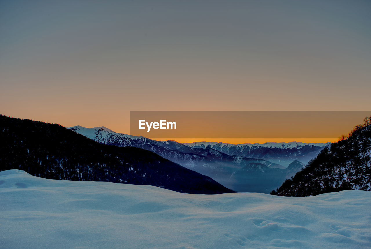 SCENIC VIEW OF SNOW MOUNTAINS AGAINST CLEAR SKY