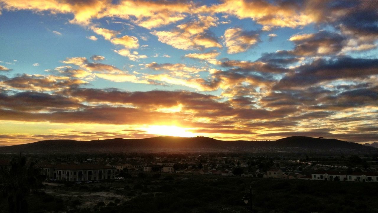 SCENIC VIEW OF MOUNTAINS AGAINST CLOUDY SKY AT SUNSET