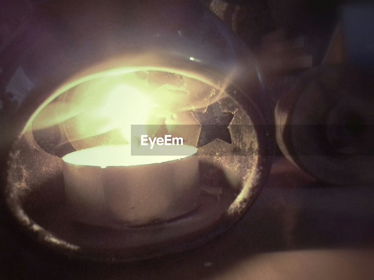 Close-up lit tea light candle on table
