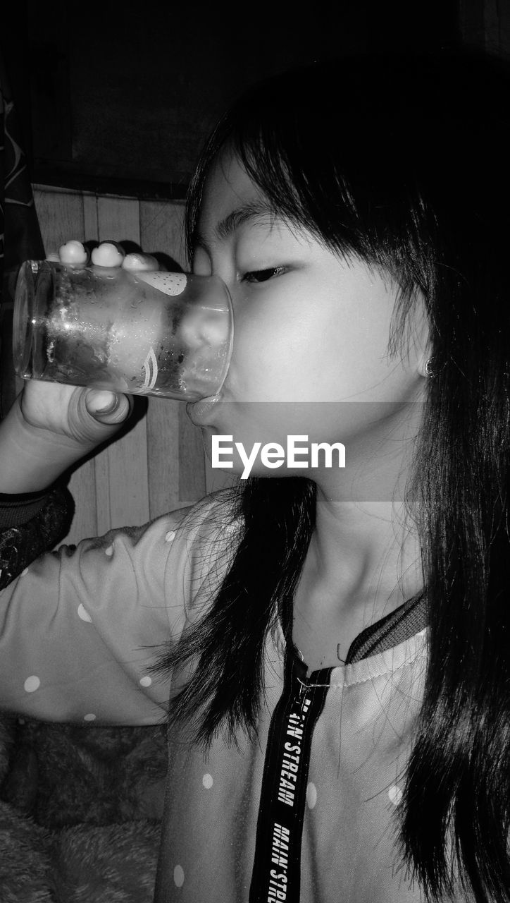 CLOSE-UP PORTRAIT OF A GIRL DRINKING WATER