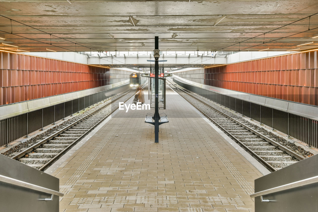 rear view of man standing on escalator