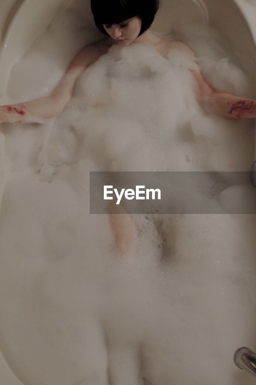 High angle view of dead woman bleeding in bathtub