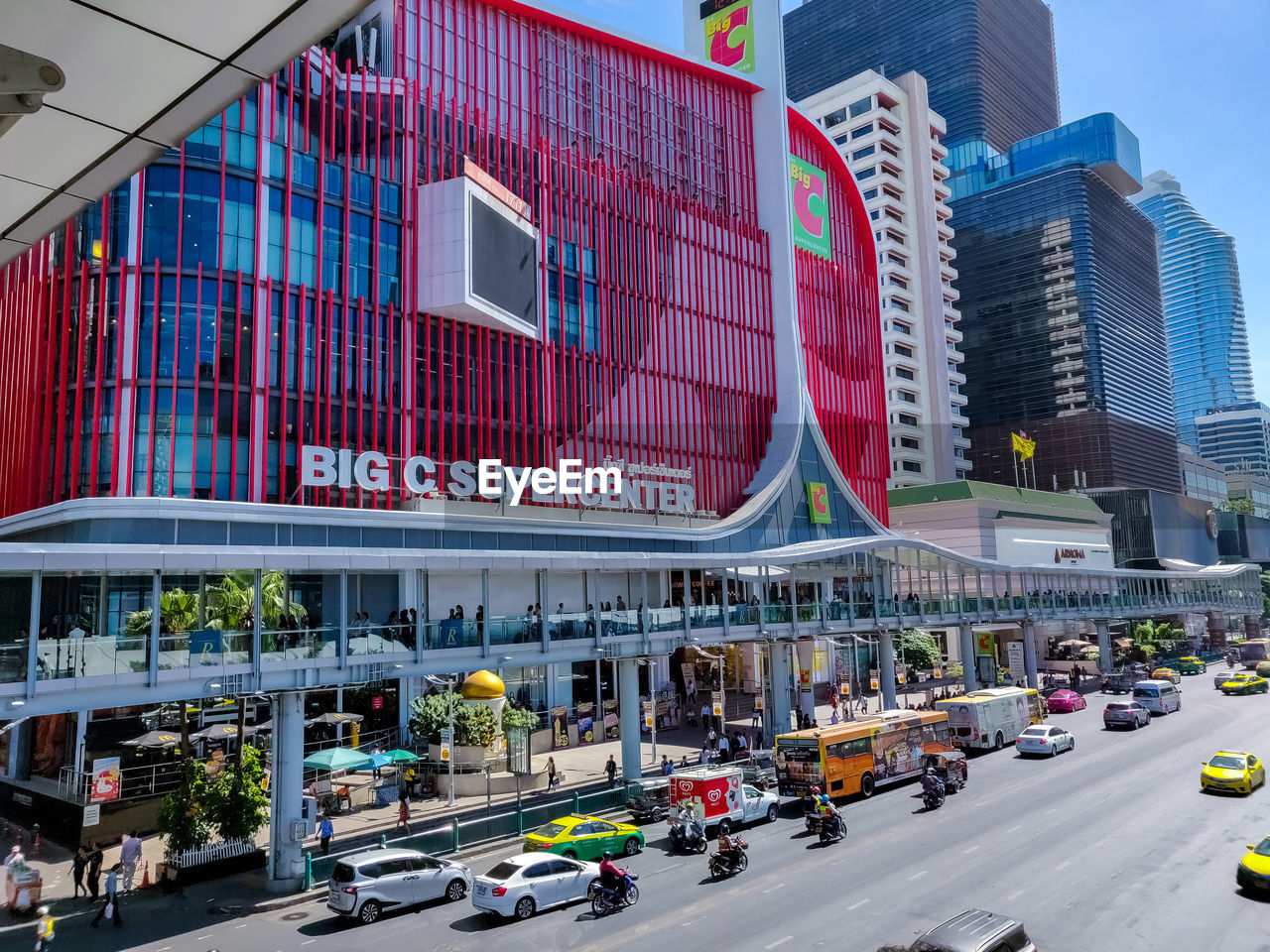 TRAFFIC ON CITY STREET BY MODERN BUILDINGS IN BACKGROUND