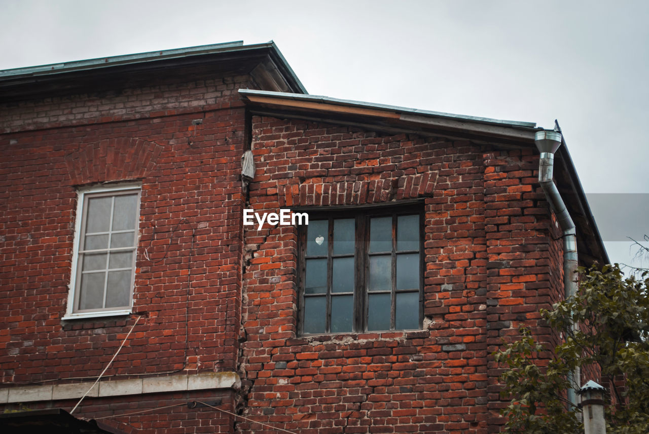 LOW ANGLE VIEW OF OLD HOUSE AGAINST SKY