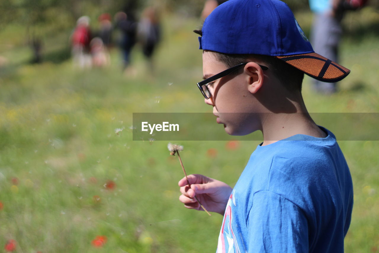 Close-up of boy blowing dandelion seeds