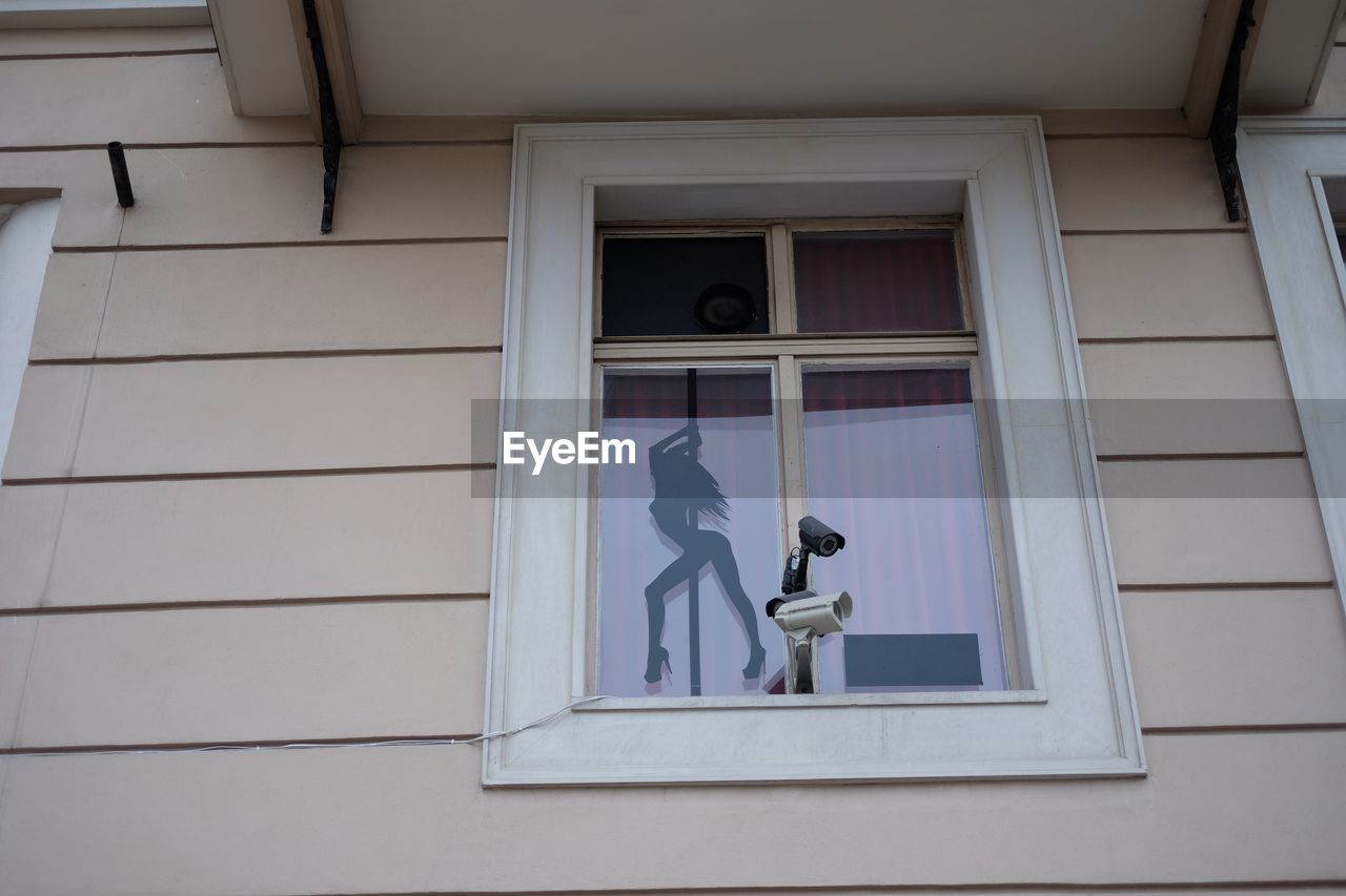 Low angle view of security camera outside house window