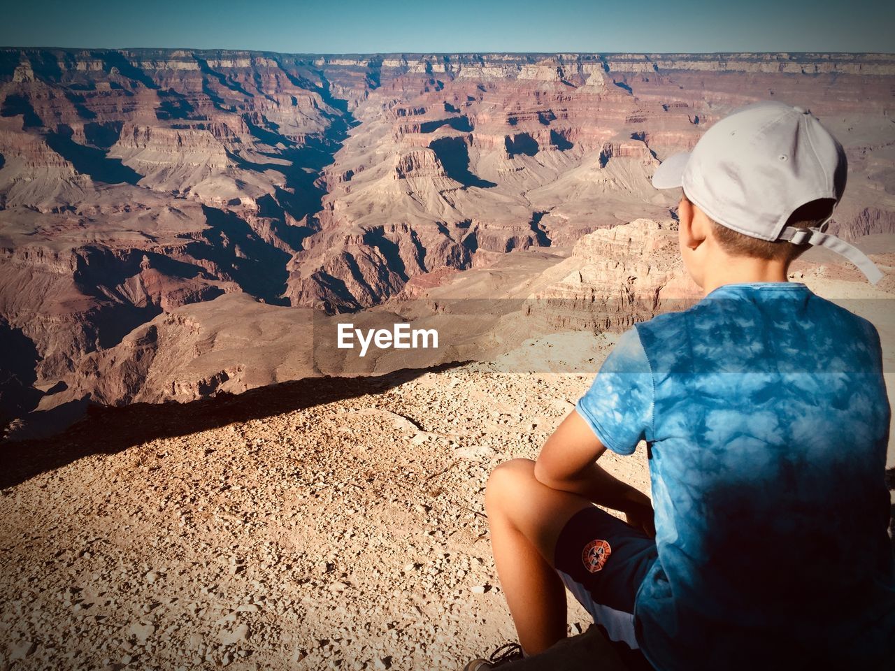 Rear view of boy sitting at grand canyon national park 