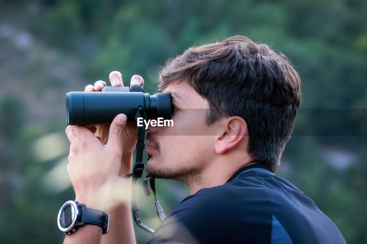 A man observes animals in nature with binoculars. birdwatching