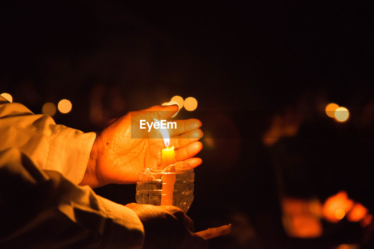 MAN HOLDING BURNING CANDLES