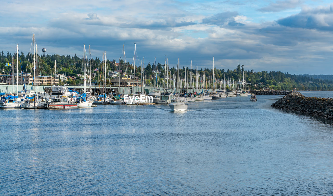 water, nautical vessel, marina, transportation, sea, sailboat, sky, mode of transportation, harbor, dock, cloud, ship, nature, bay, land, yacht, beauty in nature, travel, travel destinations, no people, moored, beach, mast, boat, scenics - nature, architecture, vehicle, pole, tranquility, landscape, environment, day, coast, city, idyllic, shore, holiday, blue, outdoors, vacation, sailing, channel, tranquil scene, pier, trip, watercraft, tourism, port, waterfront, tree, building exterior, coastline, sailing ship