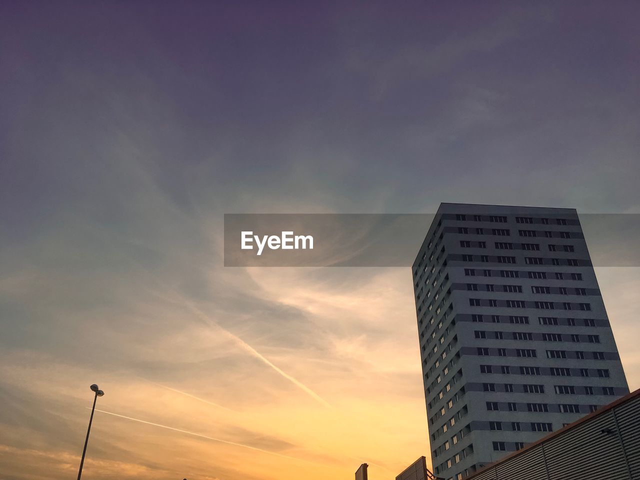 LOW ANGLE VIEW OF BUILDINGS AGAINST SKY DURING SUNSET