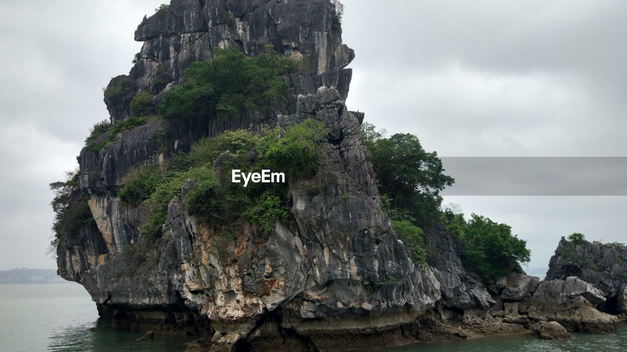 SCENIC VIEW OF ROCK FORMATION BY SEA AGAINST SKY