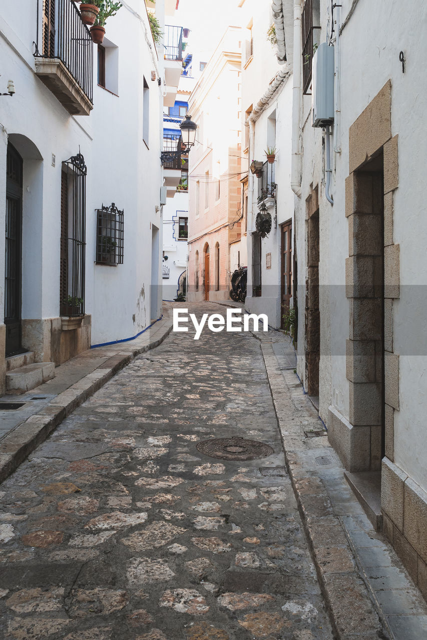 NARROW FOOTPATH AMIDST BUILDINGS IN CITY