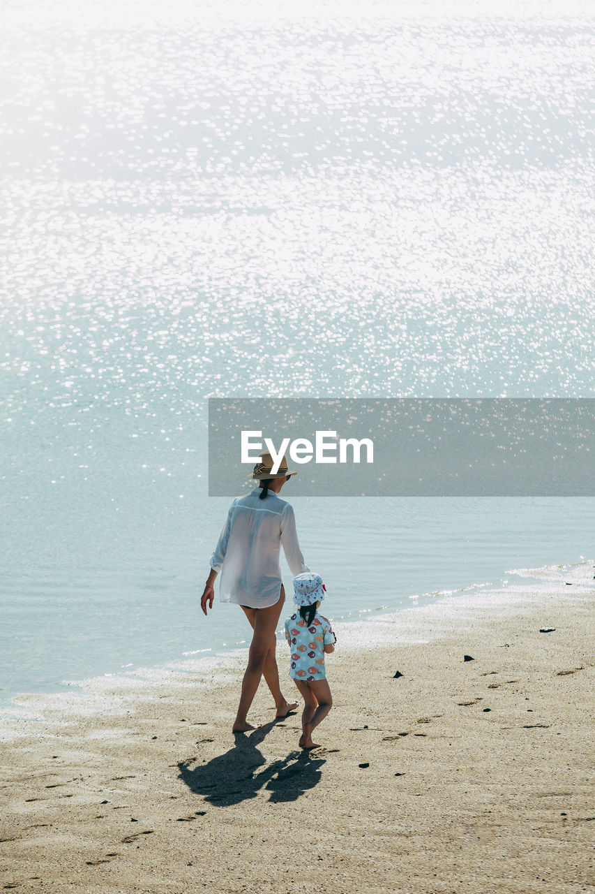 Mother and daughter walking on the beach