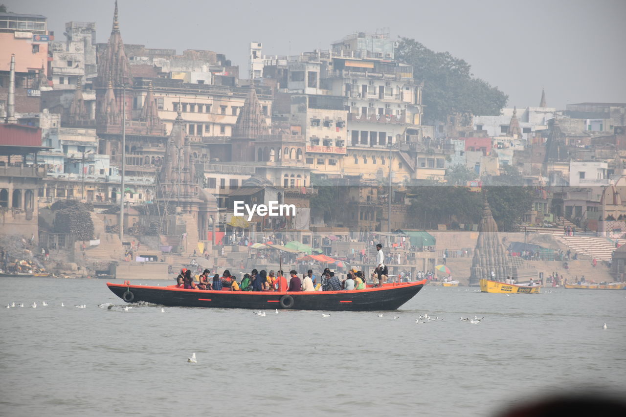 Boats in ganges against buildings in city