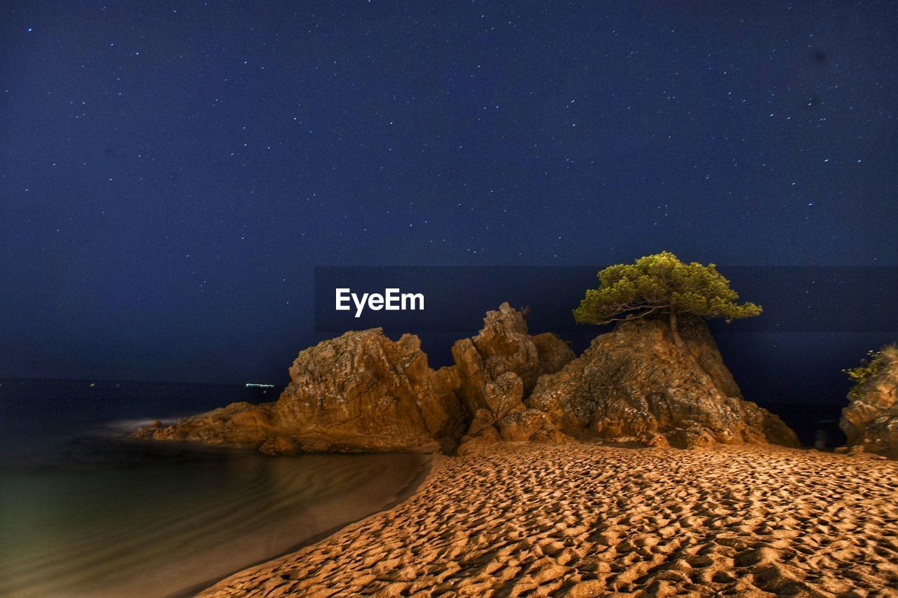 Scenic view of rock formation against sky at night