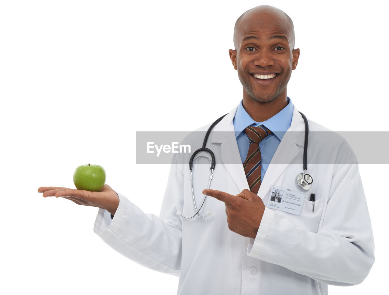 smiling, portrait, stethoscope, adult, looking at camera, healthcare and medicine, fruit, occupation, happiness, medical supplies, medical instrument, doctor, one person, physician, studio shot, healthy eating, lab coat, medical equipment, cheerful, white background, cut out, person, men, wellbeing, indoors, emotion, waist up, standing, clothing, food, apple - fruit, professional occupation, expertise, shaved head, food and drink, smile, teeth, front view, positive emotion, medicine, white, healthcare worker