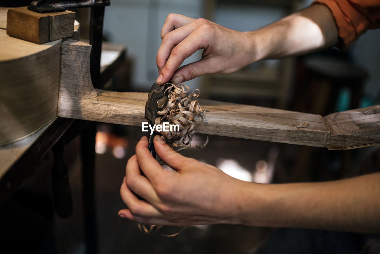 Unrecognized luthier woman in traditional workshop