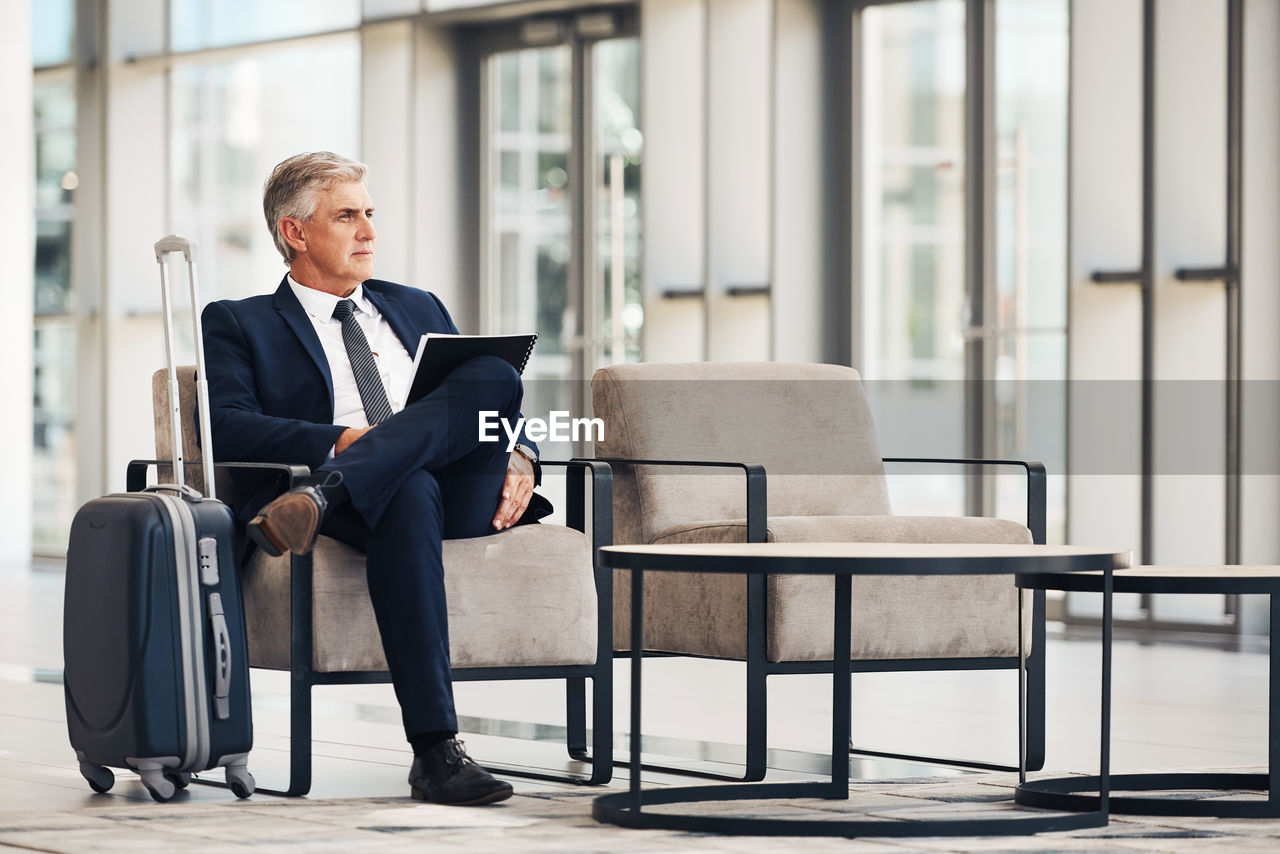 Full length of man sitting on chair