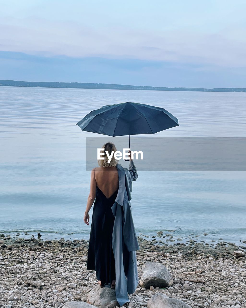 Elegant woman with umbrella looking in the se