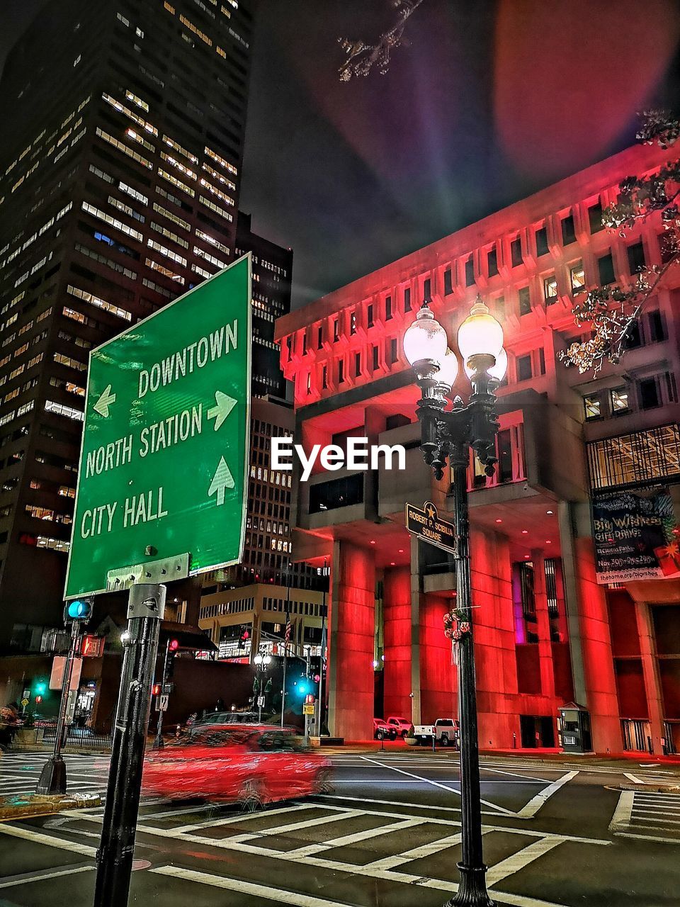 ILLUMINATED ROAD SIGN ON STREET AT NIGHT