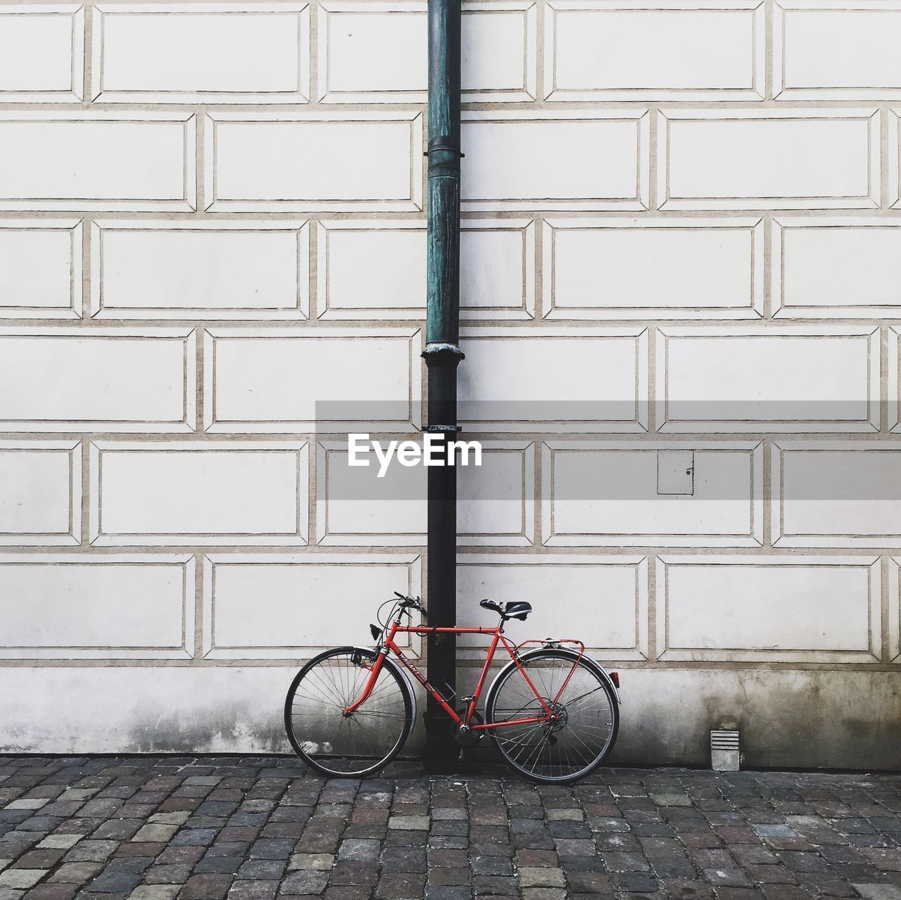 Bicycle leaning against pipe