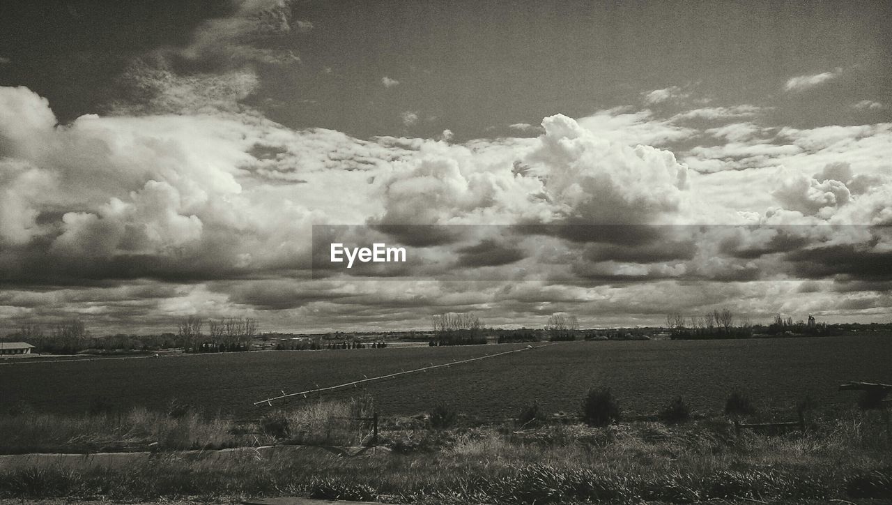 VIEW OF FIELD AGAINST CLOUDY SKY