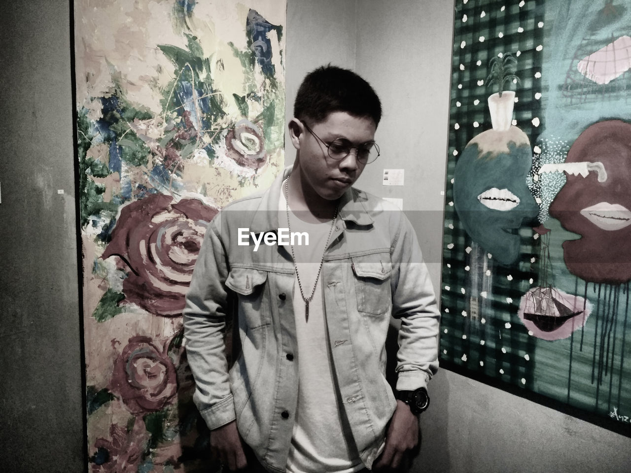 PORTRAIT OF YOUNG MAN STANDING AGAINST CURTAIN