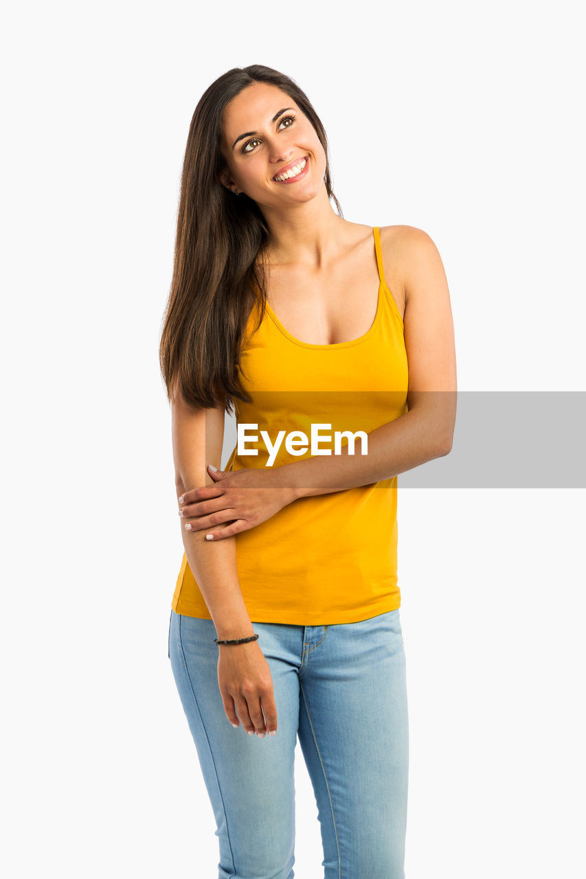 PORTRAIT OF SMILING WOMAN AGAINST WHITE BACKGROUND