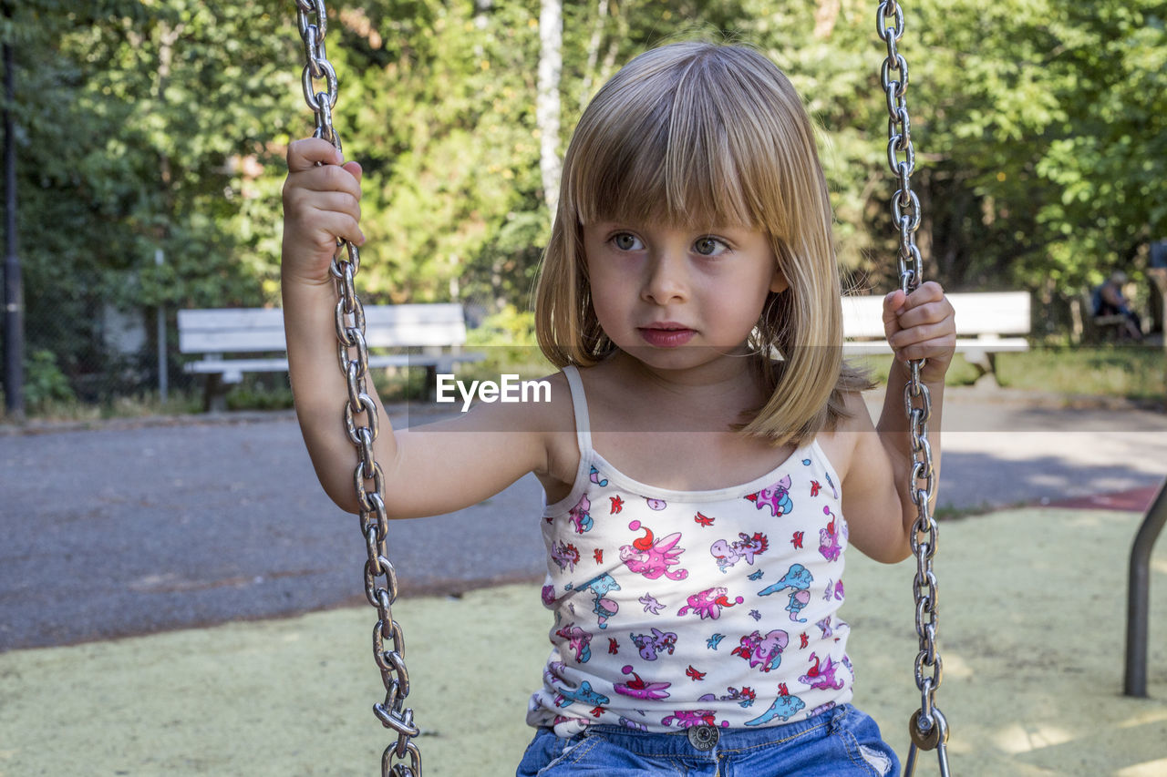 Portrait of girl on swing at the playground