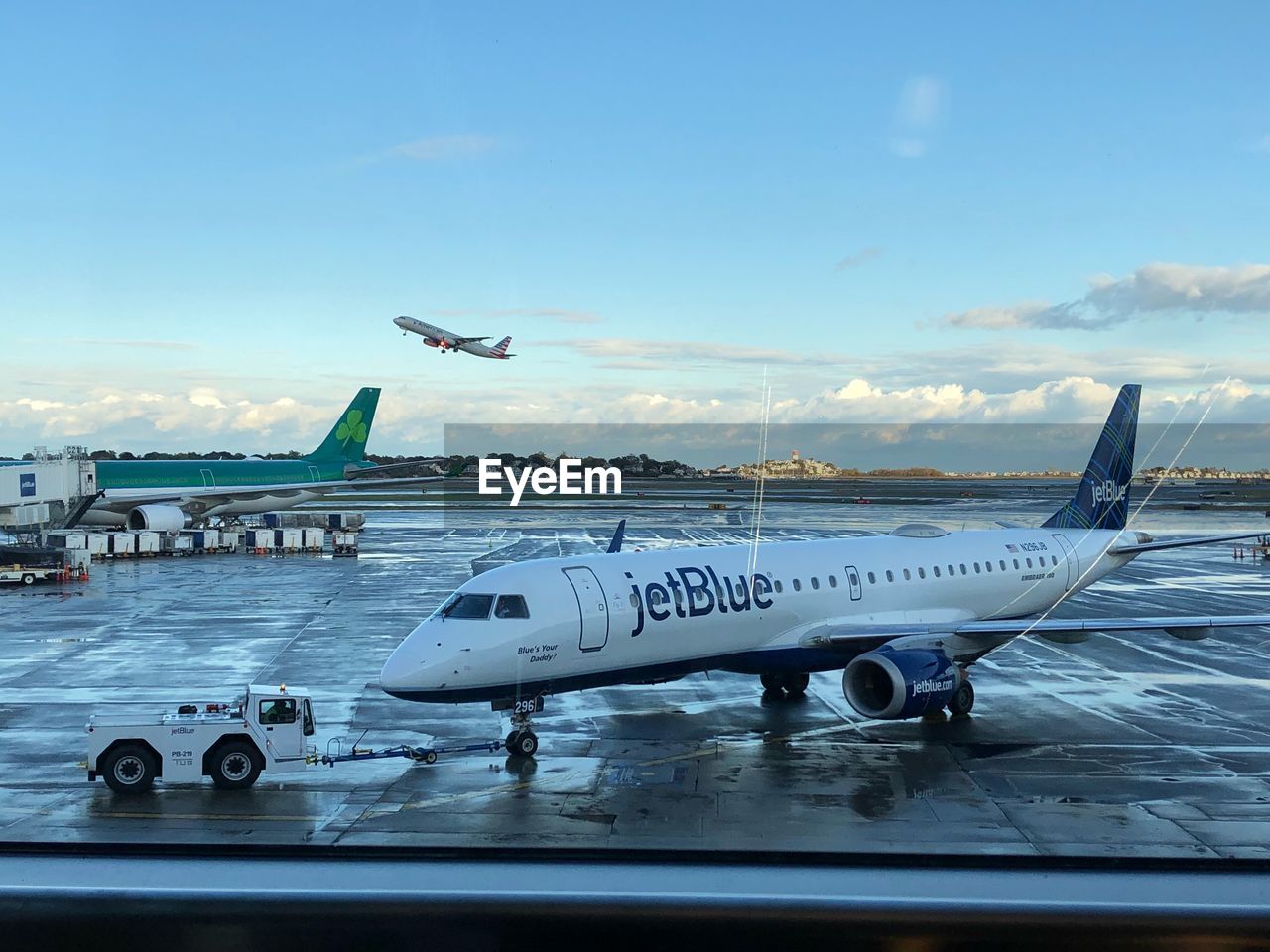 AIRPLANE FLYING OVER AIRPORT AGAINST SKY