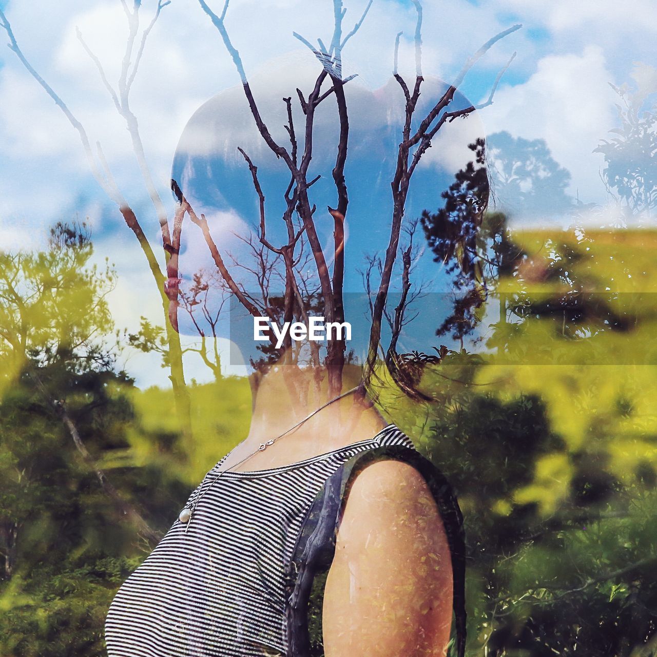 Double exposure of woman and bare trees against sky
