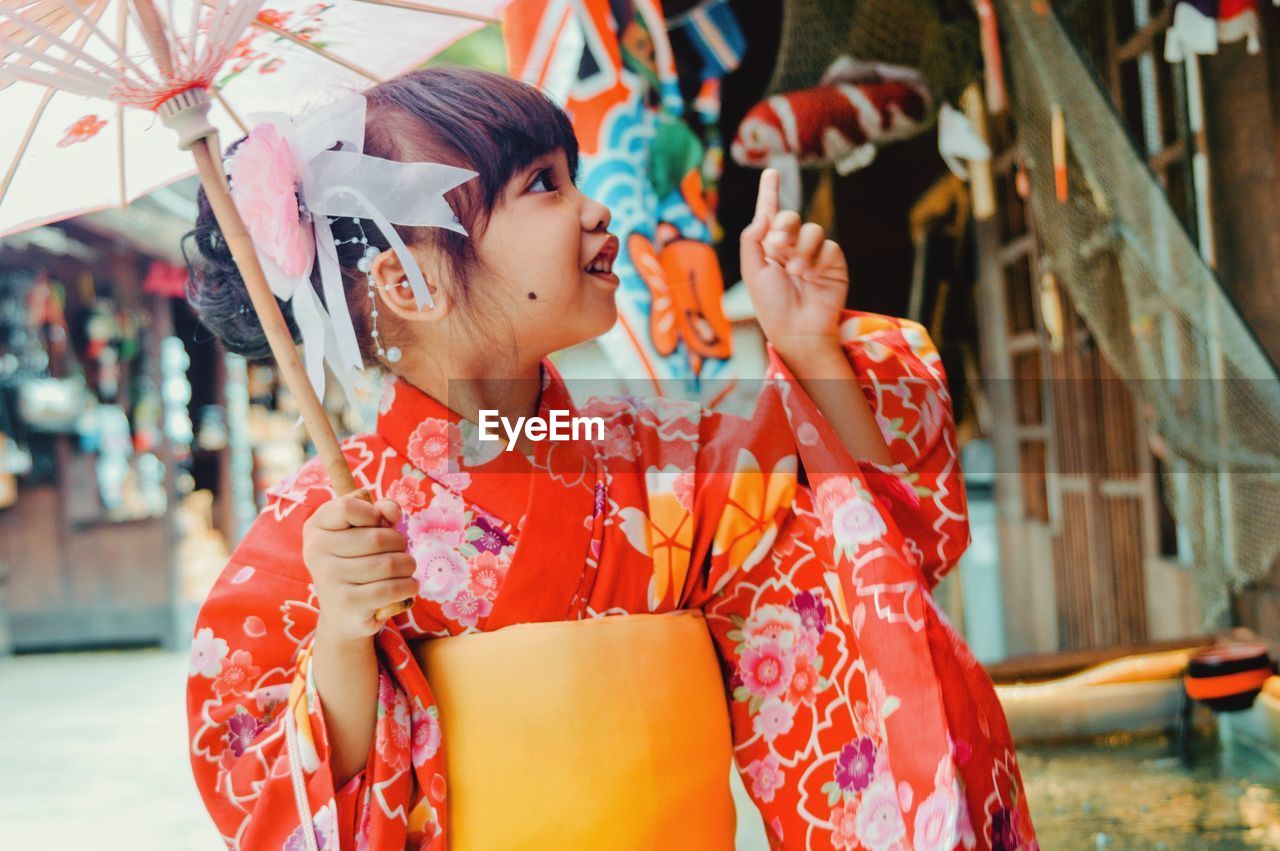 A litle girl wearing a red kimono