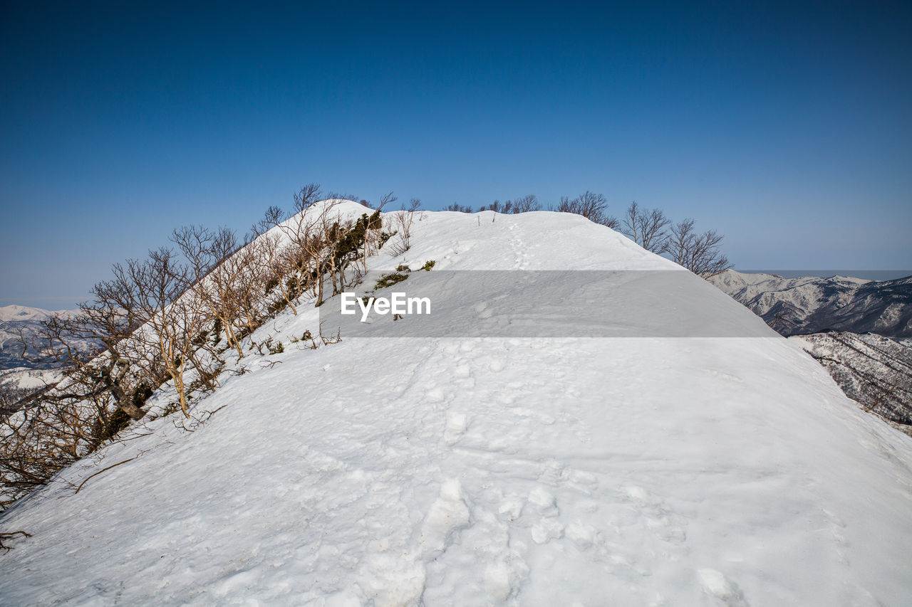 SNOW COVERED LANDSCAPE AGAINST SKY