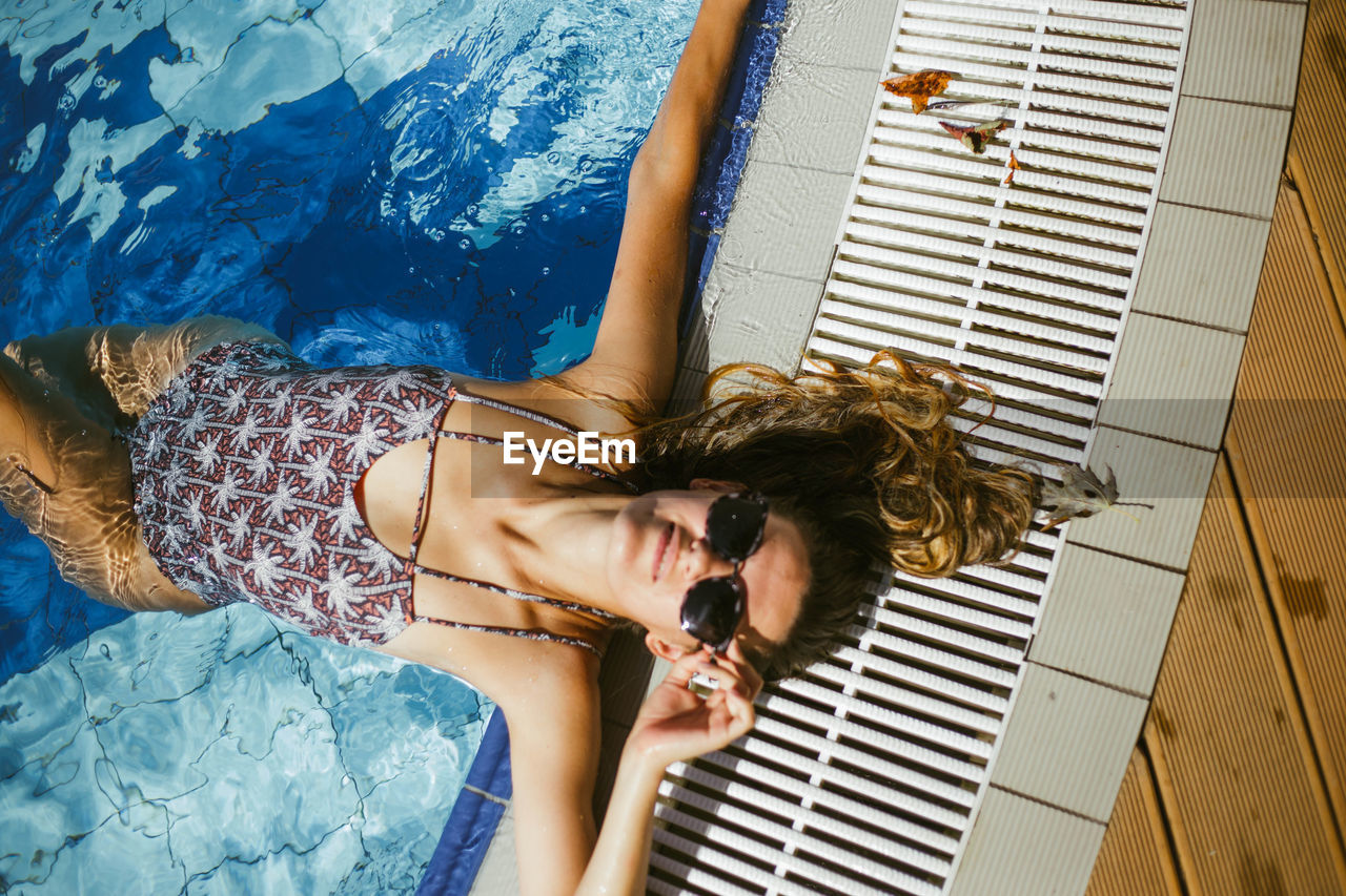 High angle portrait of woman relaxing in swimming pool