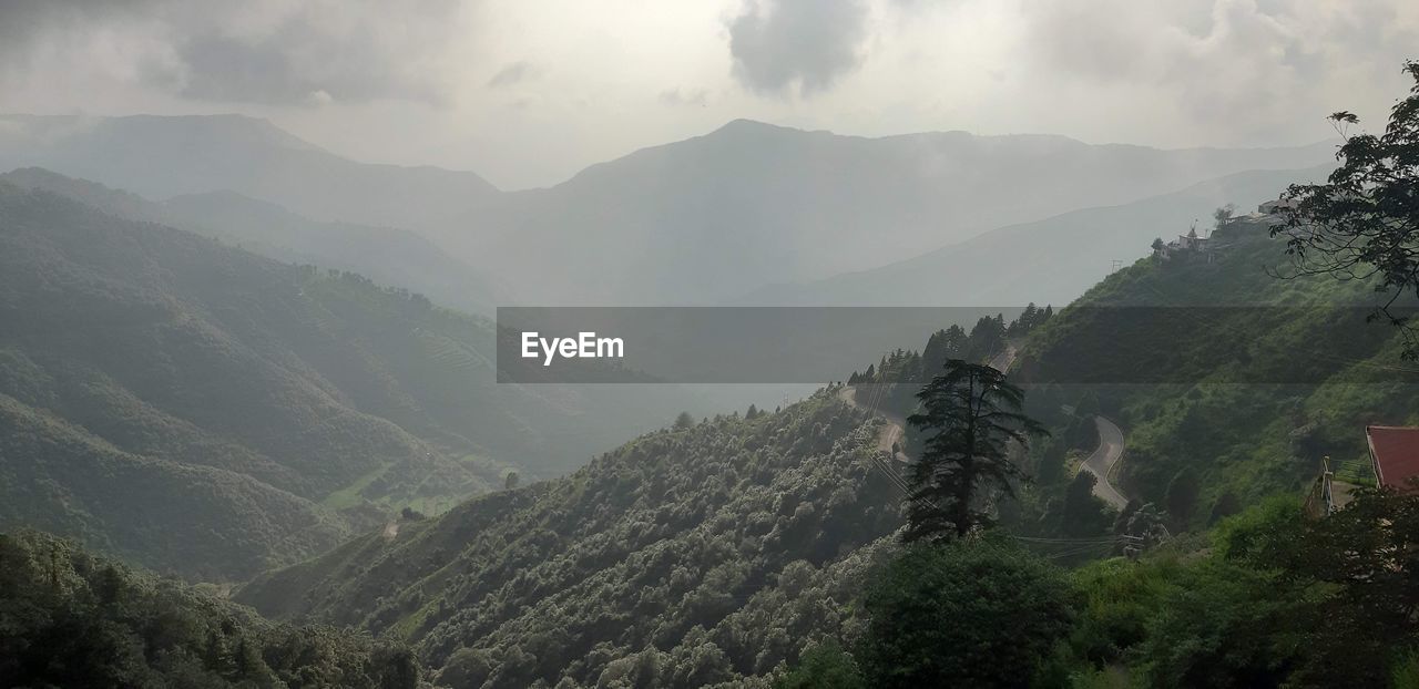 PANORAMIC VIEW OF MOUNTAIN RANGE AGAINST SKY