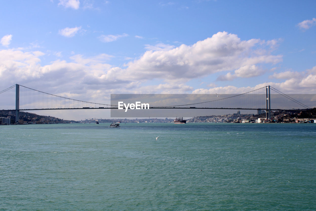 bridge, water, architecture, built structure, transportation, suspension bridge, sky, travel destinations, sea, travel, tourism, city, nature, engineering, cloud, scenics - nature, bay, bay of water, beauty in nature, cityscape, landscape, building exterior, tranquility, tranquil scene, copy space, nautical vessel, urban skyline, land, blue, mode of transportation, outdoors, environment, day, holiday, beach, horizon, dramatic sky, building, waterfront, idyllic, cable-stayed bridge, coastline, long, trip, city life, vacation, business finance and industry, sunlight, summer, panoramic, atmospheric mood, water's edge, shore, vehicle, road, street, rippled, industry, highway, coast, shipping, business, sunny, tall ship