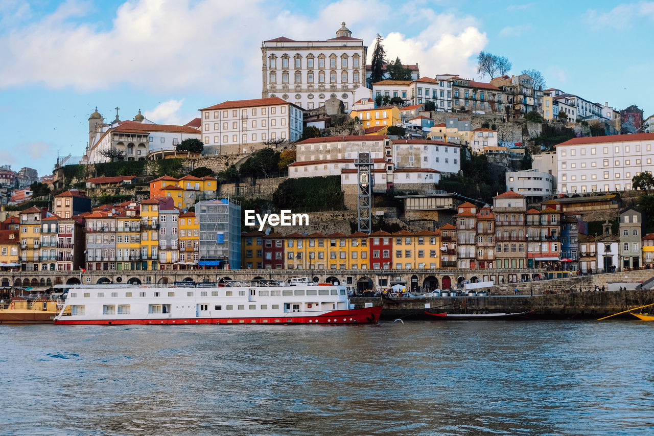 Buildings by sea against sky in city