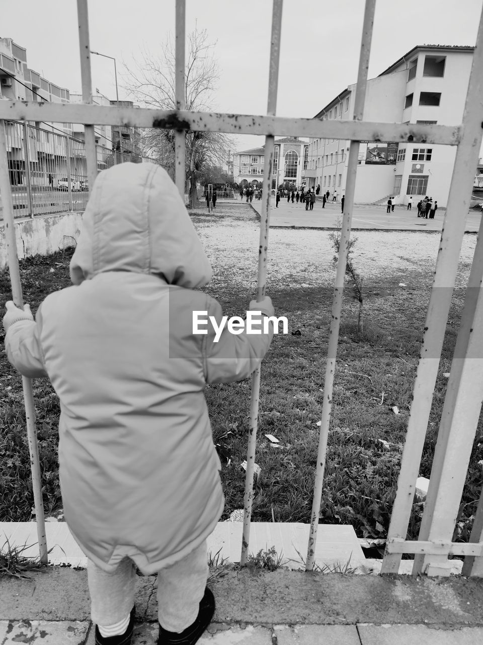 white, rear view, black and white, monochrome, men, monochrome photography, architecture, street, full length, one person, day, built structure, sky, adult, lifestyles, building exterior, black, nature, child, outdoors, city, childhood, occupation, road, casual clothing, person, leisure activity