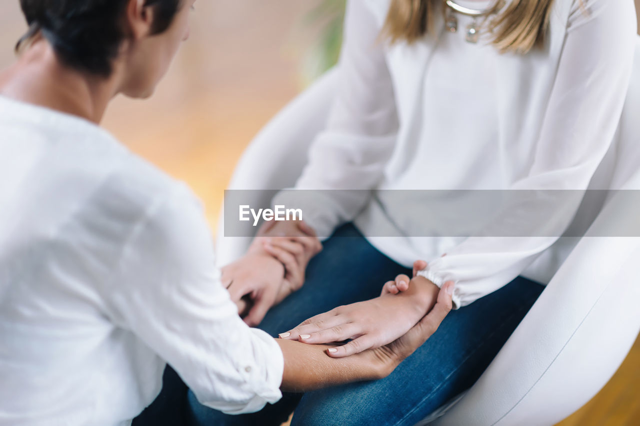 Midsection of doctor giving therapy to patient at hospital